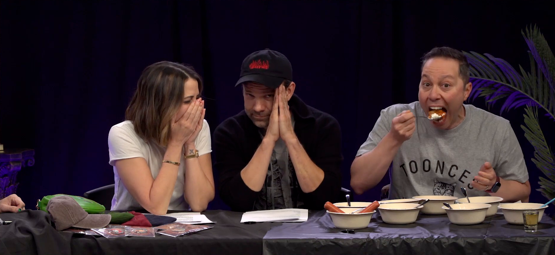 The white text “VIEWER DISCRETION
            ADVISED” over a black background. On hover, the image changes to
            Laura, Liam, and Sam sitting at the Critical Role Announcement
            Playhouse table. Sam eats a spoonful of strawberry ice cream and
            kimchi, his mouth wide as he looking into the camera. Laura and Liam
            look disgusted. Laura is covering her nose and mouth with her hands.
            Liam is blocking his vision of Sam with his hands and looking
            directly into the camera. In front of Sam are eight bowls of food
            with spoons coming out of them. Two hotdogs are coming out of one of
            the bowls. A shot glass of Malört is next to the bowls.
