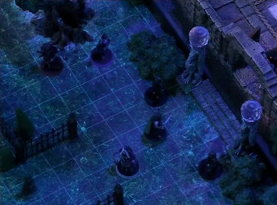 A battlemap of a stone palace courtyard focused on the palace entrance. Julien and Vaelus stand back to back, with Thaisha and Occtis nearby. Two stone pillars bearing carvings of griffins and topped with large spherical crystals frame the entryway, near to two black-clothed individuals. The gate out of the courtyard lies open, guarded by one more black-clothed individual.