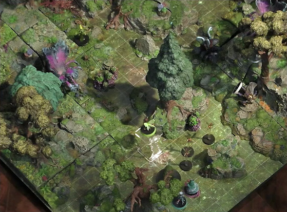 A battlemap of a forested glade with a variety of trees, mushrooms, and fey-like, purple plants. Teor lies on his back on a rocky outcropping. Three pixies fly in the middle of the party. Wicander and Tyranny face off against a shambling mound. Thimble flies 10 feet in the air near a tree.