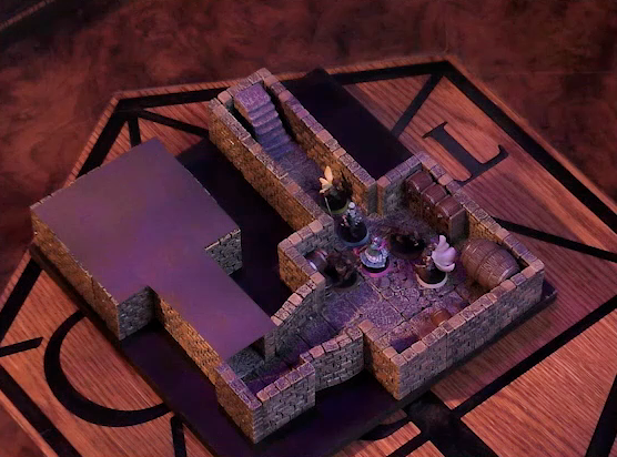 A battlemap of a small stone dungeon. A short set of stairs go down into a hallway which leads to a chamber containing some barrels against the walls. Wicander, Tyranny, Wulferic, Kattigan, and stand in the barrel chamber, with Thimble just outside in the hallway leading into it. Another hallway leads off and turns a corner into a second chamber. Most of this final hallway and chamber are obscured with black construction paper, with only the start of the hallway before it turns uncovered.
