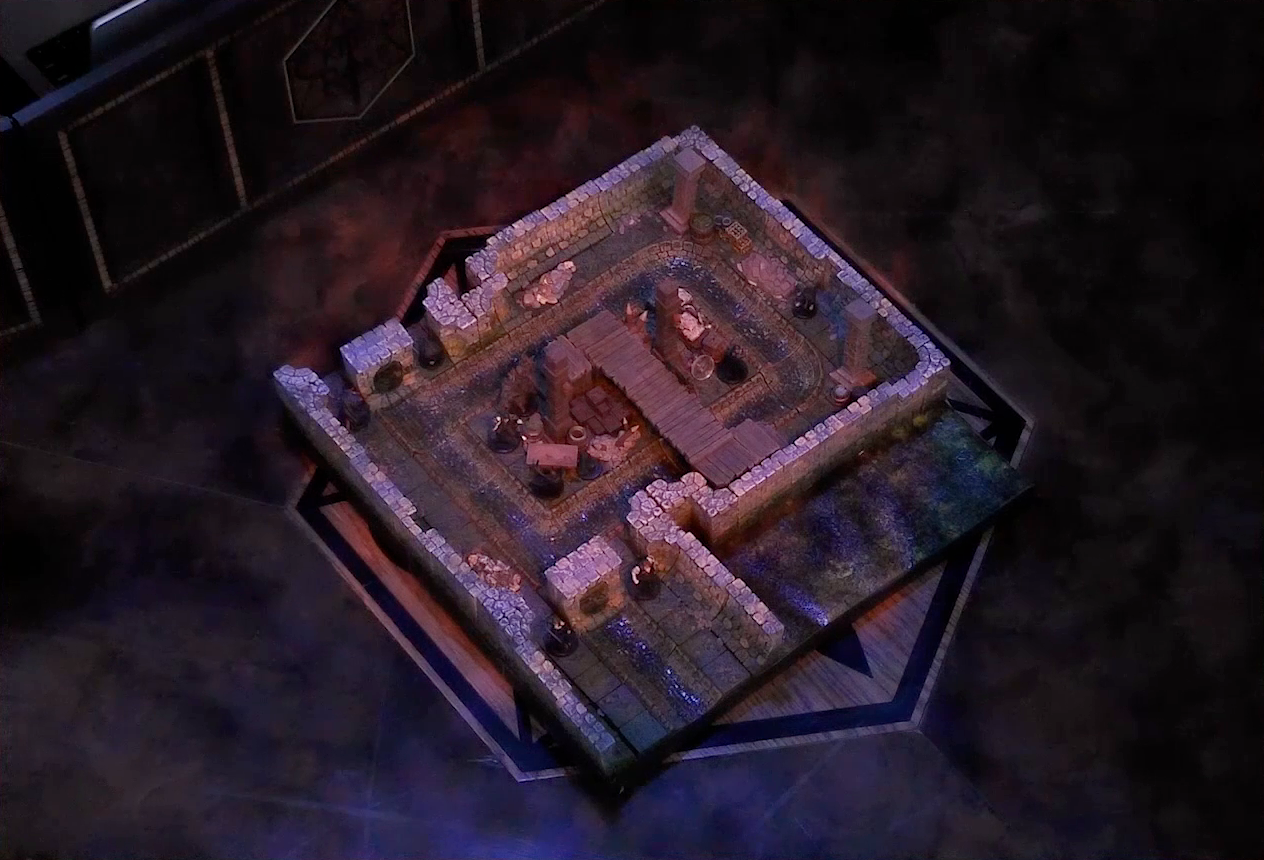 A battlemap of a stone underground room in the sewer. Five Crow Keepers stand within the room around a fallen Demodus Blix, while two guard an entrance on one side and two guard an entrance on the opposite side. The entrances have sewer grates set into them. A sewer trench runs in a circle in the room and exits through both entrances. A raised wooden boardwalk goes from the wall to the center of the room among wooden boxes and three stone pillars holding up the ceiling.