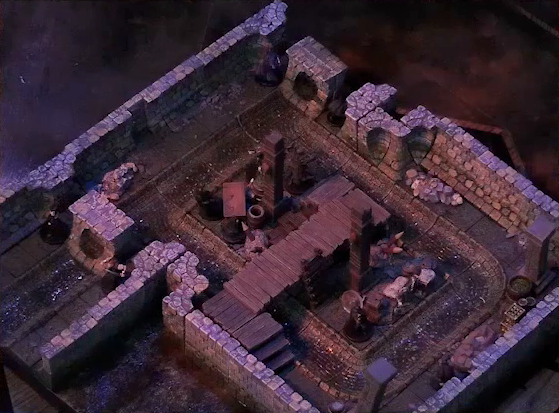 A battlemap of a stone underground room in the sewer. Five Crow Keepers stand within the room around a fallen Demodus Blix, while two guard an entrance on one side and two guard an entrance on the opposite side. The entrances have sewer grates set into them. A sewer trench runs in a circle in the room and exits through both entrances. A raised wooden boardwalk goes from the wall to the center of the room among wooden boxes and three stone pillars holding up the ceiling.