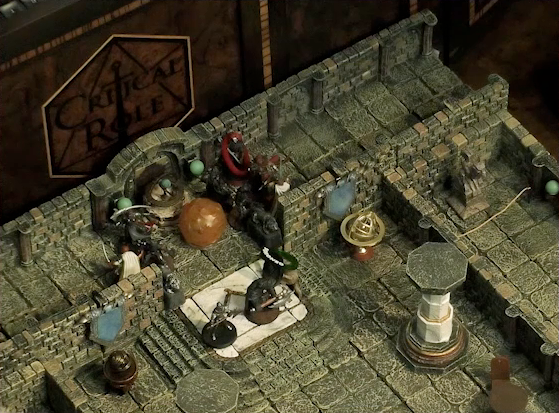 A battlemap of a large stone banquet chamber with surrounding hallways. Azune and Bolaire face off against six assassins entering the chamber through its north entrance. A Flaming Sphere floats among the assassins. A fallen Hound of the King with a “POISONED” status ring lays on the ground just inside the entrance. Bolaire has a red status ring around his miniature. Inside the chamber are marble pillars holding up the ceiling. Inside the chamber are some long tables and chairs, marble pillars holding up the ceiling, and an orrery.