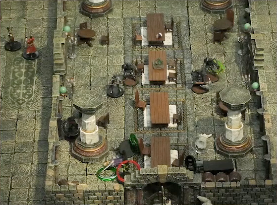 A battlemap of a large stone banquet chamber with surrounding hallways. Four assassins cross the room towards a table at the south end. One of the assassins has a green status ring around its miniature. At one end of the table are King Augustus Valian with a “POISONED” status ring, a Hound with a “POISONED” status ring, and a druid with a red status ring. At the other end are Photarch Yanessa and an attendant Lux. All but the druid are on the ground. Murray hides invisibly behind a nearby pillar. Two party guests are in the west hallway outside the chamber. Outside the south entrance is Filoneus Halovar with his two dogs Wrath and Judgement.