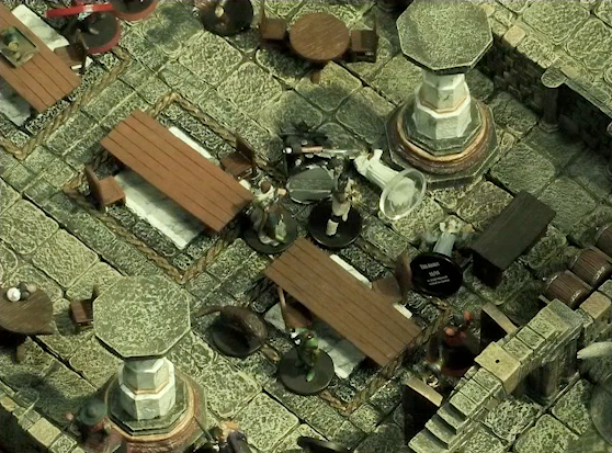 A battlemap of a large stone banquet chamber with surrounding hallways. Filoneus Halovar stands over the body of the fallen Photarch Yanessa, as well as a fallen assassin. An attendant Lux lies next to the Photarch. Looking on are a Timmonish knight, a Hound, a druid, Azune, and Bolaire.