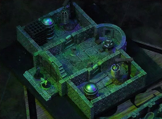 A battlemap of a stone aviary split into three rooms. Occtis and Thimble stand outside a closed door into the main chamber, in which are two ghouls and a circular table with a card game abandoned on it. To the left of the main chamber is a closed door leading to a room with a large cubic black metal cage, a large cylindrical silvery metal cage, and a large cylindrical metal hanging cage resembling a bird cage. To the right of the main chamber is a closed door leading to a room with the same kind of silvery metal cage and hanging cage, although there is no large cubic cage.