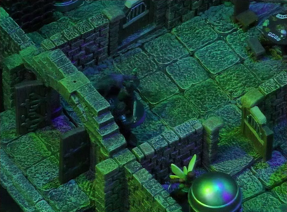 A battlemap of a stone aviary split into three rooms. Julien, Occtis, and Occtis’s undead monitor lizard stand in the open door to the main chamber. Thimble is in an open room to the right of the main chamber in front of a large cylindrical silvery metal cage. At the rear of the main chamber is a circular table with a card game abandoned on it. To the left of the main chamber is a closed door leading to another room.