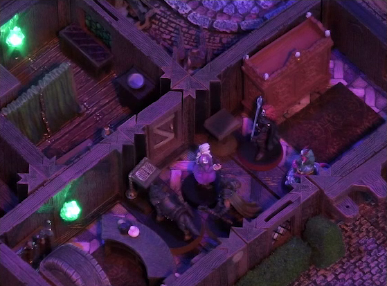 A battlemap of a street-side tailor shop eerily tinted purple and lit by glowing green torches. Kattigan, Wulferic, Tyranny, Bolaire, and Calastro Mercanaud stand in a main entry room in front of a curved front desk. A wardrobe is behind the desk and another one painted red is on the other side of the room. A door leads from the room to an adjoining one with curtains dividing it partially down the center.