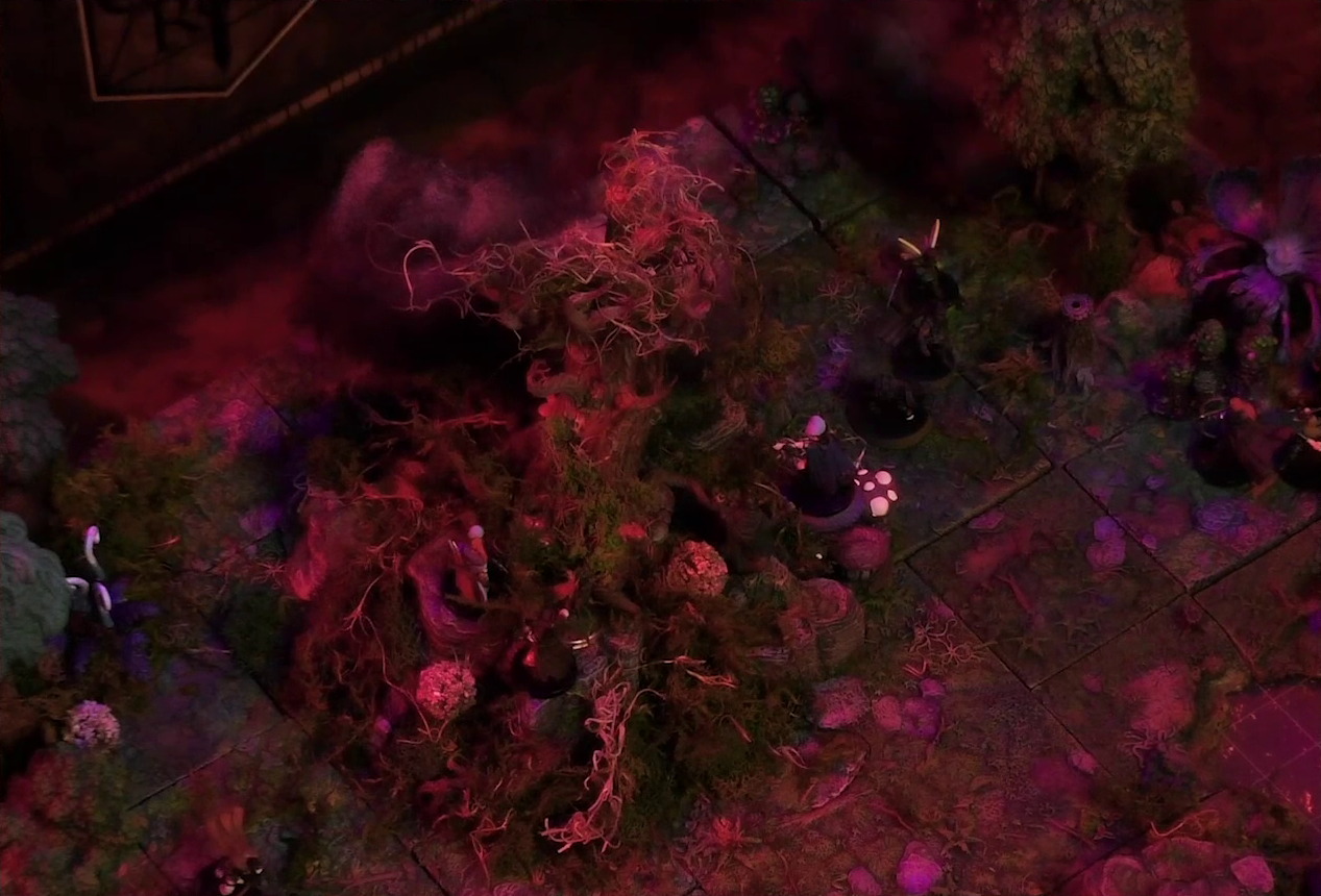 A battlemap of a forest clearing with a large leafless Hawthorn tree near the center. Fake smoke rises from that tree and others at the edges of the map. Thimble, Kattigan, and Wulferic stand near the tree. A number of Candescent Creed members and fairy poachers are scattered around the area, especially at the base of the Hawthorn tree. A huge purple flower is at the edge of the map.