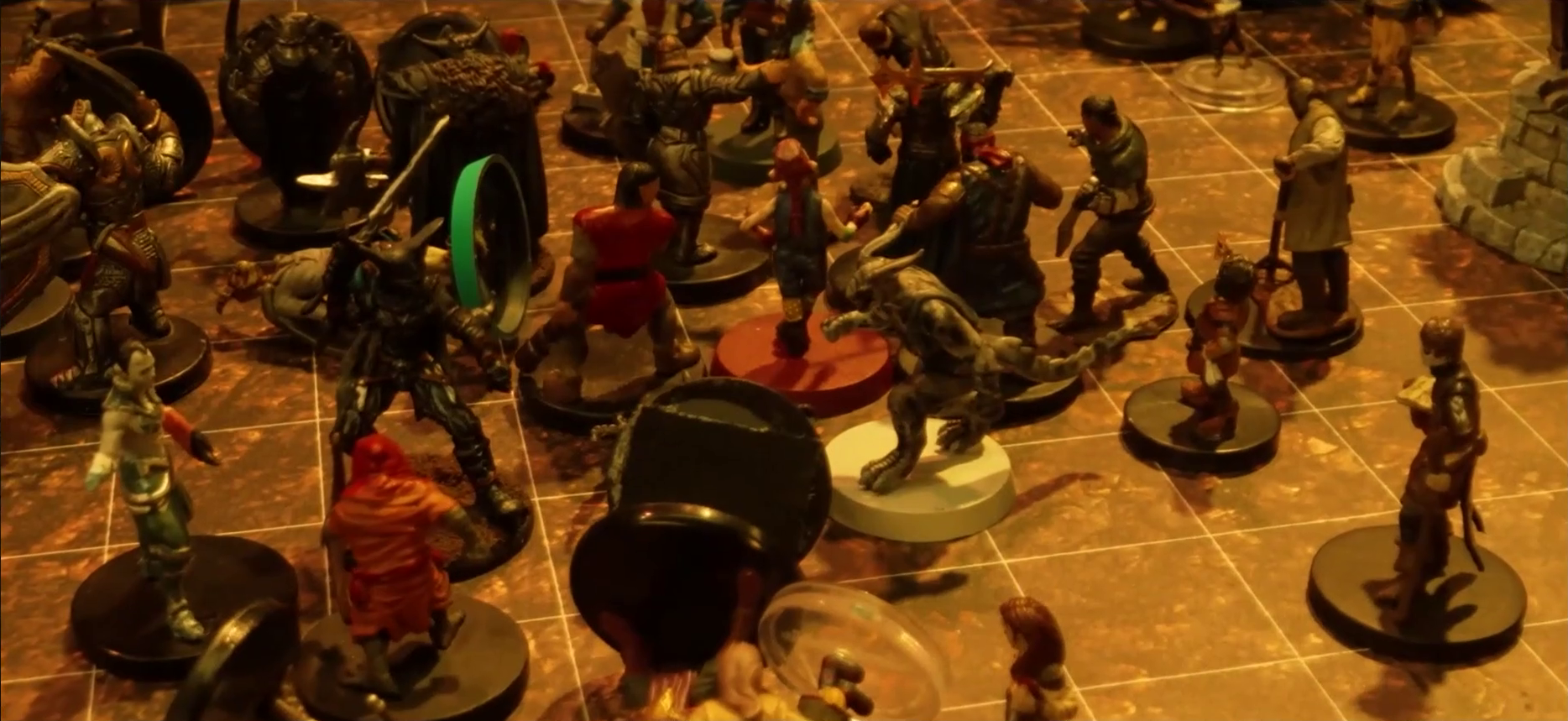 A battlemap focused on a fight between a group of black-armored soldiers and Fiedra, Crokas, and a number of villagers. Erro lays on the ground, with a number of villagers also downed. A soldier lays on the ground in front of Fiedra and Crokas. A stone well is visible at the edge of the image.