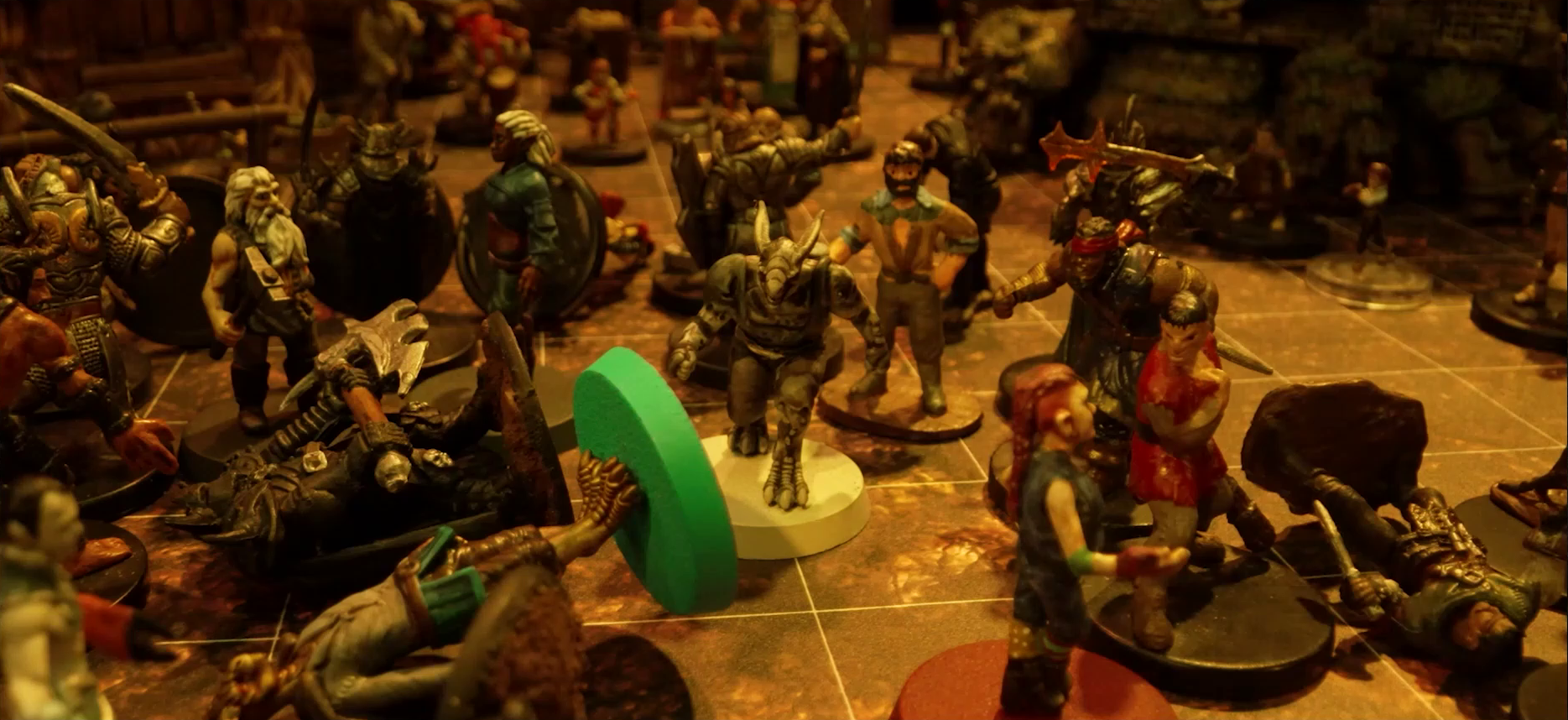 A battlemap focused on Crokas in the midst of a melee between him, Fiedra, Rei’nia, Garen, and a number of villagers against a group of black-armored soldiers. Some villagers lay on the ground, as does the commanding soldier (wielding a large axe) and Erro. Visible in the background is a wooden building as well as some more villagers a distance back.