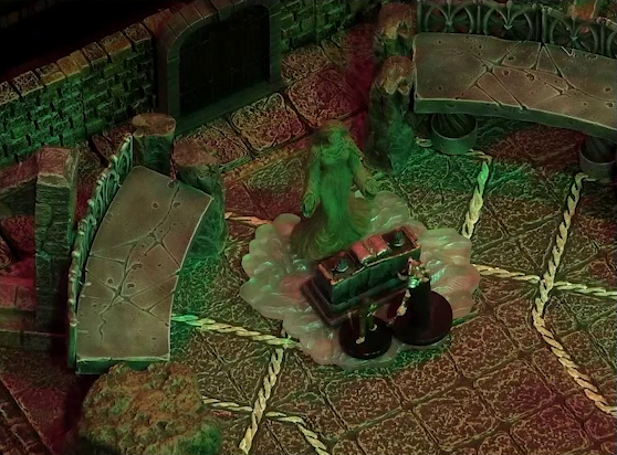 A battlemap of a stone temple interior focused on Lord Callister and Timothy standing before an altar and statue of the Moonweaver. The statue sits in front of a dark archway between two stone platforms, and stands on a bed of white crystal. On the altar is an open book.