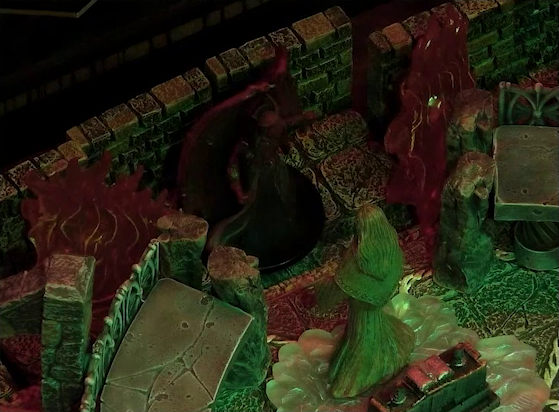 A battlemap of a stone temple interior focused on the large winged Asmodeus standing with his back to a wall in front of a statue of the Moonweaver who is rotated to face him. On either side of Asmodeus are large fires. The statue stands on a bed of white crystal in front of an altar with an open book on it.
