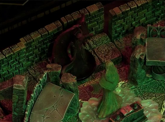 A battlemap of a stone temple interior focused on the large winged Asmodeus standing with his back to a wall in front of a statue of the Moonweaver who is rotated to face him. There is no longer fire on either side of Asmodeus. The statue stands on a bed of white crystal in front of an altar with an open book on it.