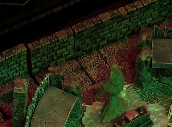 A battlemap of a stone temple interior focused on a statue of the Moonweaver who is rotated to face the back wall where Asmodeus stood in previous images. The statue stands on a bed of white crystal in front of an altar with an open book on it.