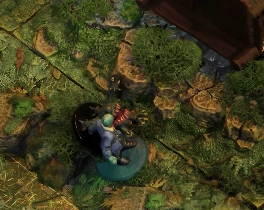 A close-up of Jessep and a monster miniature on a wooded battlemap. The monster is a small ball-shaped creature with its torso split open in a toothy maw, two clawed hands emerging from its headless body. The body is held up by four stubby legs. They are near to a small wooden shed.