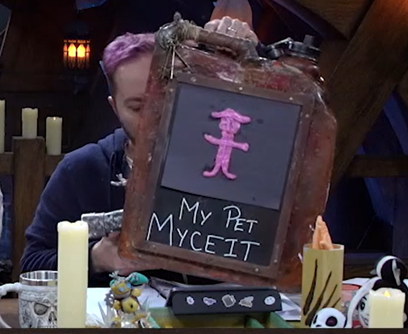 A rusty gas can with a humanoid figure made of pink gum on the side. Below is the text “MY PET MYCEIT” in thin white letters.